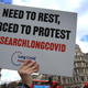 A protester holds up a placard demanding research into long covid during a demonstration in the UK this March.